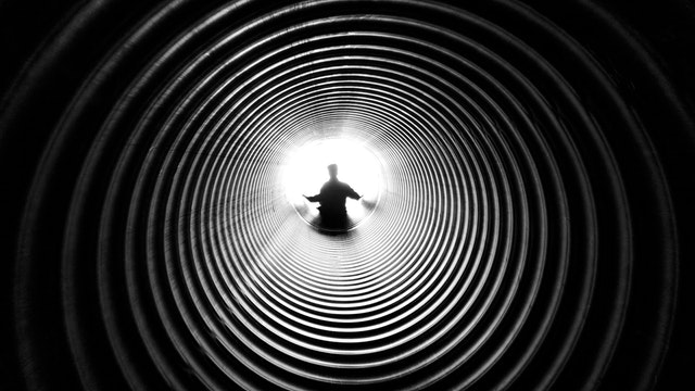 Child inside tube shaped playground slide